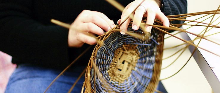A student weaving a basket